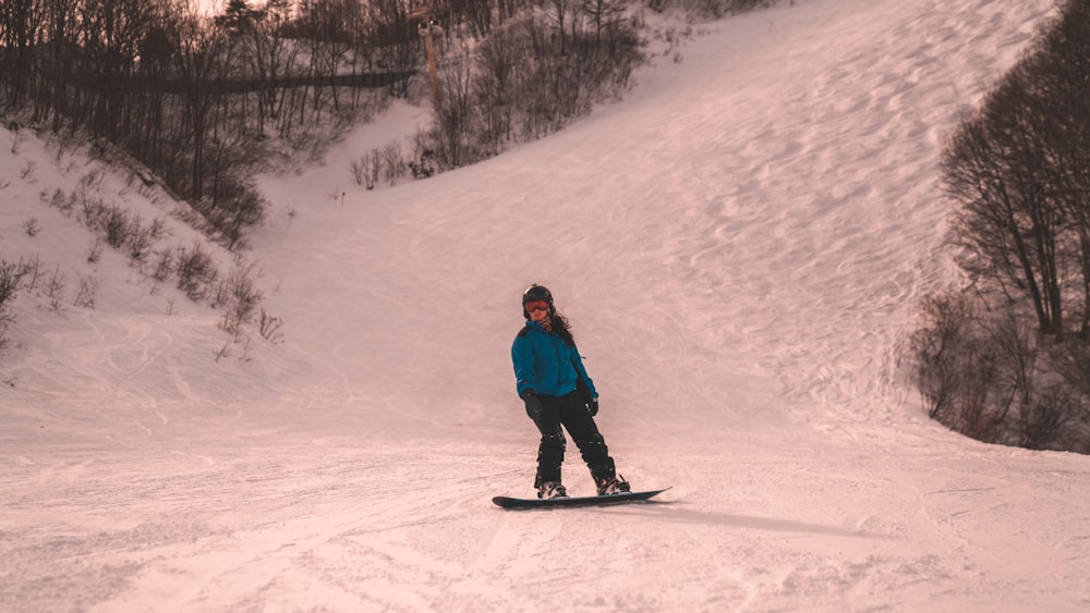 snowboarder standing on snow covered mountain