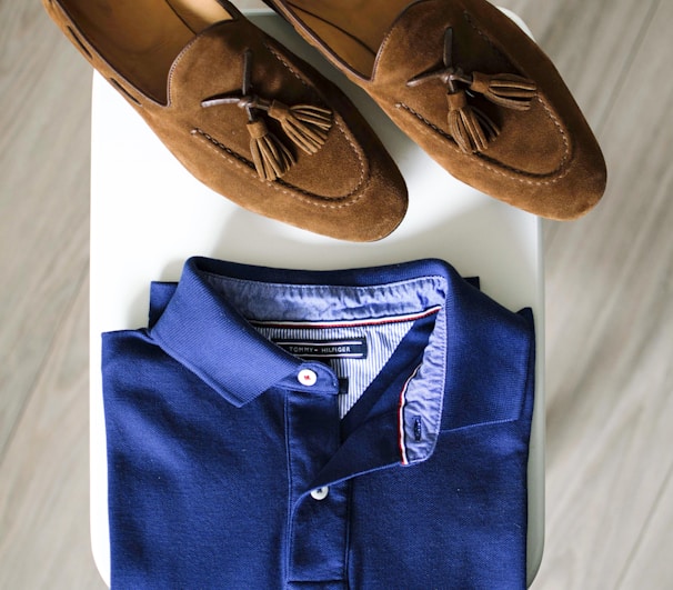 pair of brown loafers and blue polo shirt