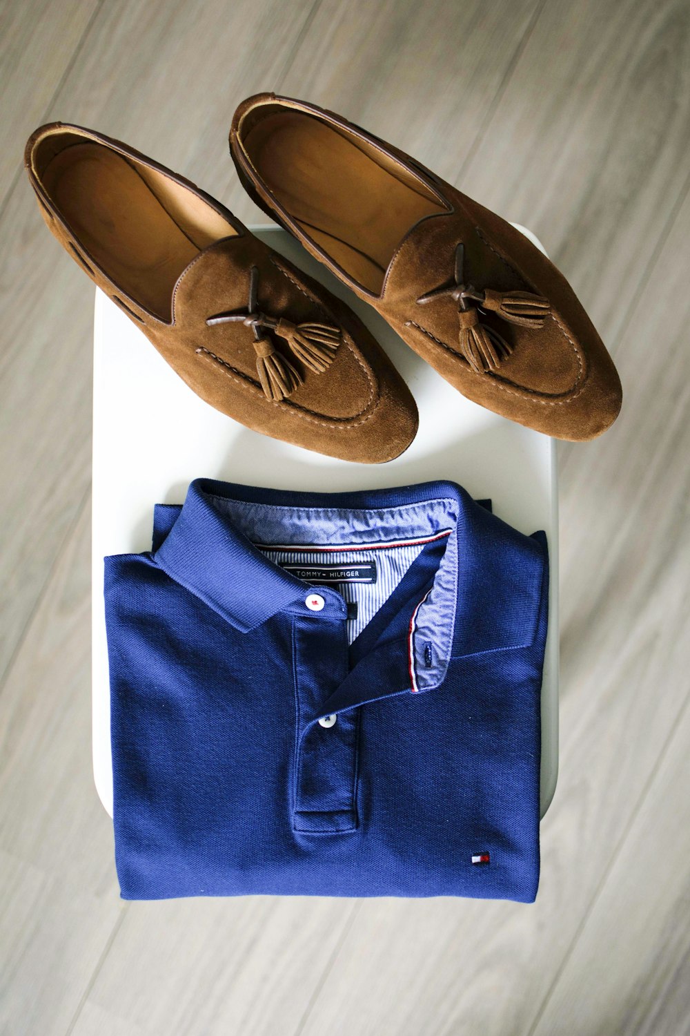 par de mocassim marrom e camisa polo azul