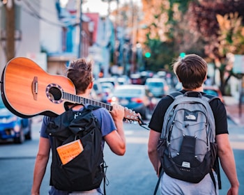 two man carrying backpacks during daytime