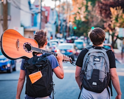 two man carrying backpacks during daytime