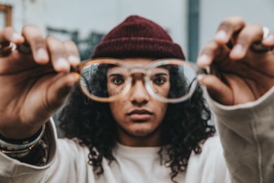person holding eyeglasses strange zoom background