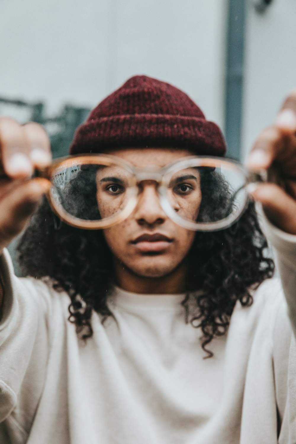 person holding eyeglasses with brown frame