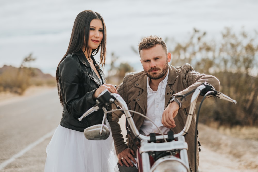 man sitting on motorcycle beside woman