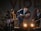 A band performing on stage with four musicians. The central figure, wearing a hat, energetically plays a mandolin. The others play various instruments including a guitar and a keyboard. Stage lighting creates a lively atmosphere as they smile and engage with the performance.
