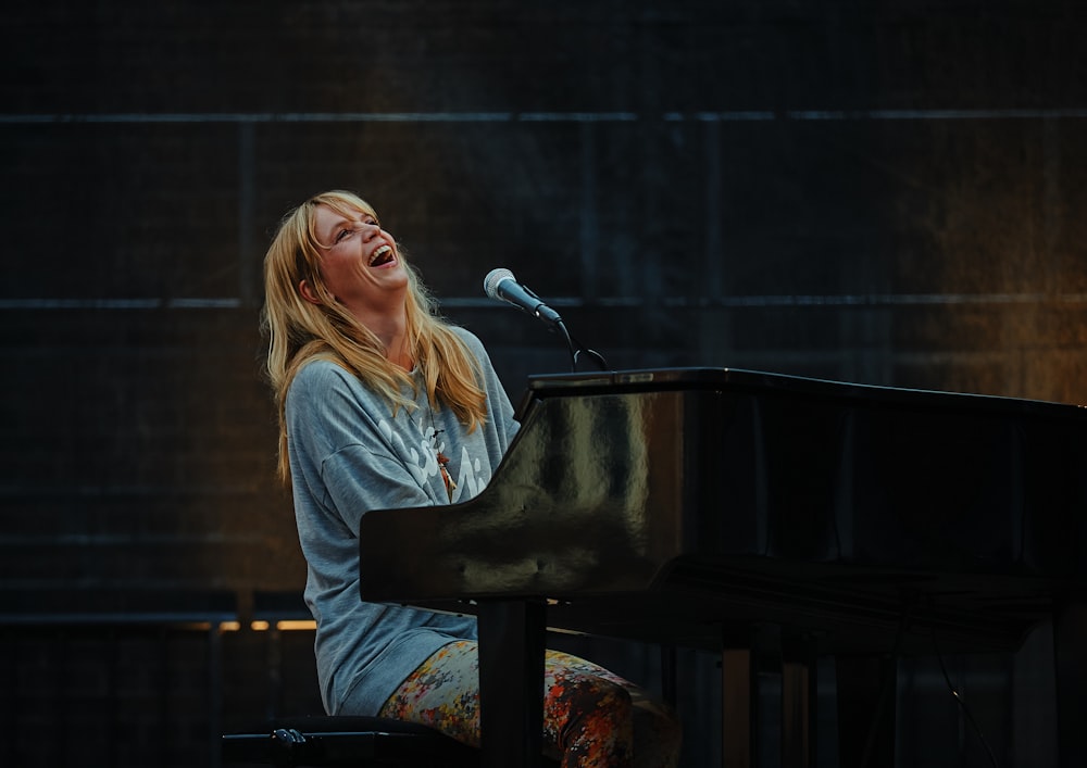 woman playing piano while laughing