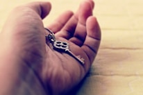 Close-up of hands exchanging a vintage key symbolizing trust and legacy.