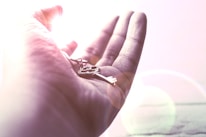 Hands gently holding a glowing key symbolizing unlocking the subconscious mind.