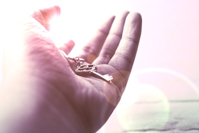 Hands gently holding a glowing key symbolizing unlocking the subconscious mind.