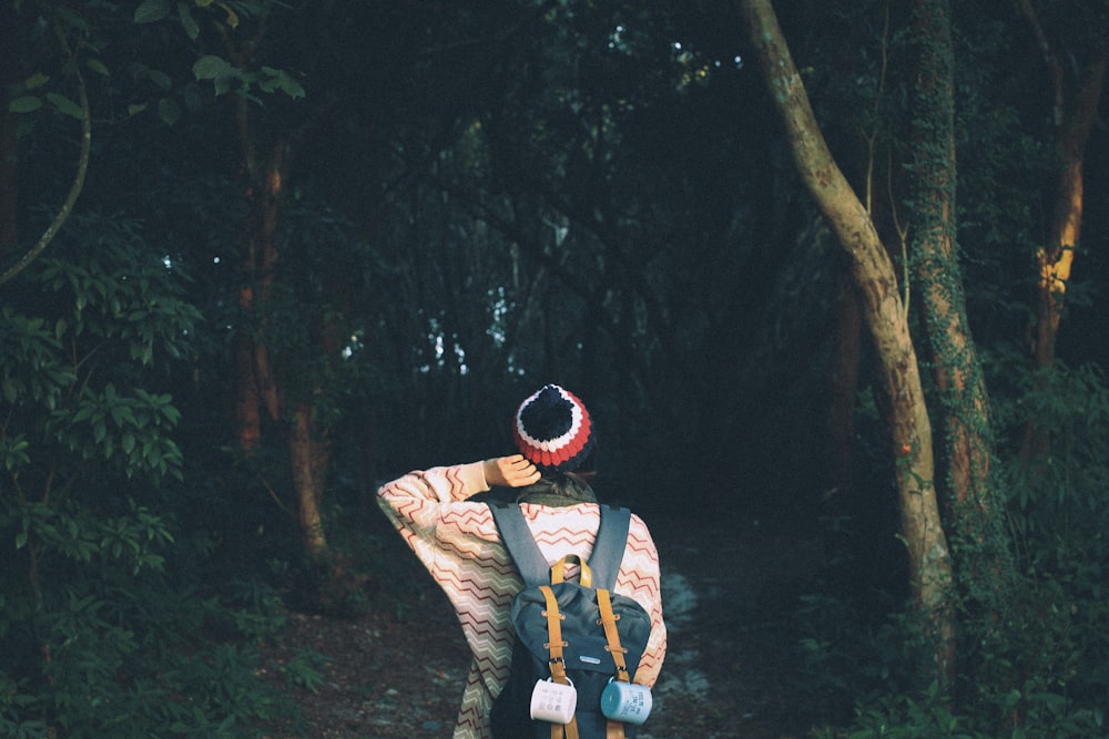 photo of woman standing front of trees