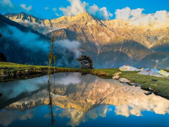 mountain reflecting on body of water in Triund India