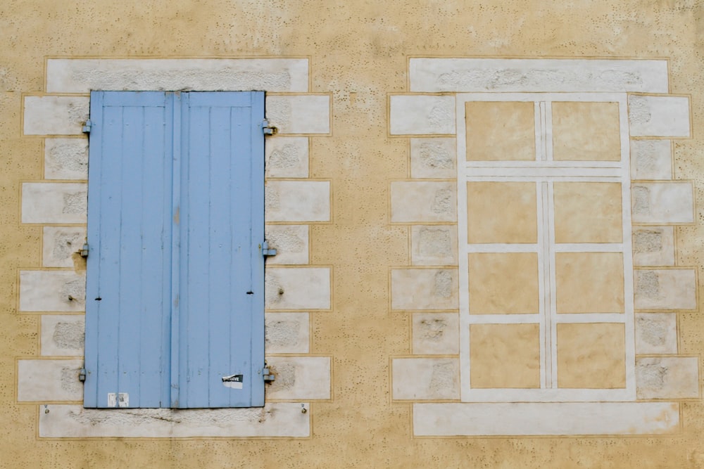 blue wooden window with white frame mountain in brown wall