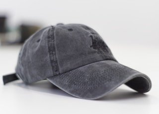 gray baseball cap on white surface