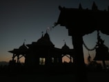 Temple bells gently swaying with a soft glow in the background at dawn.