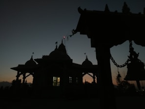 Temple bells gently swaying with a soft glow in the background at dawn.