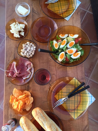 A rustic wooden table set with traditional Turkish dishes including keşkek, çığırtma, and fresh salads.
