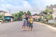 three boy standing on road
