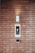 Alarm system panel mounted on a wall with a keypad and LED display.