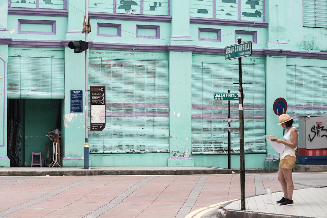 woman reading book on street during daytime