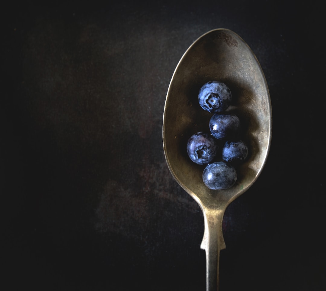 five blueberries on gold spoon