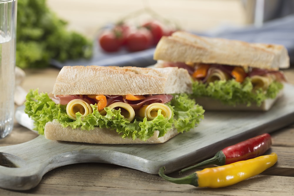 sandwich with lettuce and cheese served on chopping board