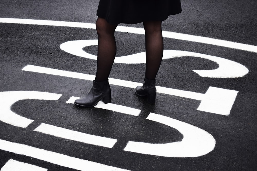 woman standing on black asphalt road