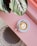 cup of coffee on saucer with teaspoon on pink tabletop