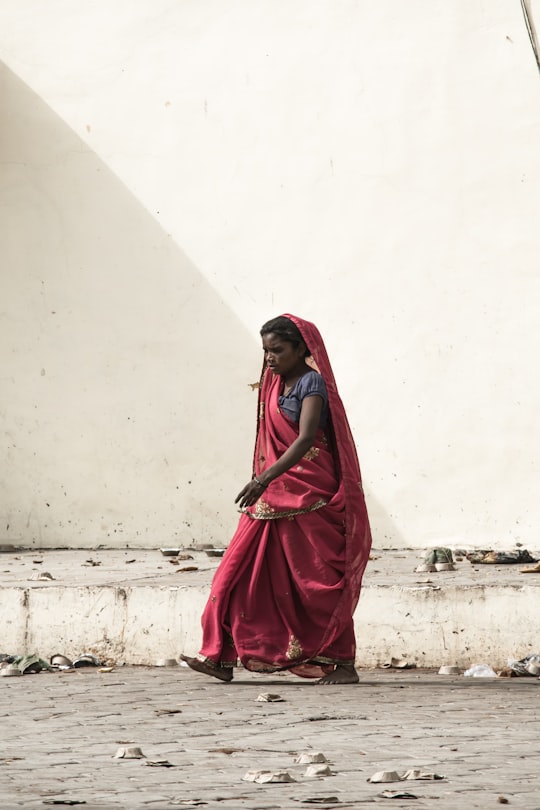 photo of woman walking on roadway in Orachha India