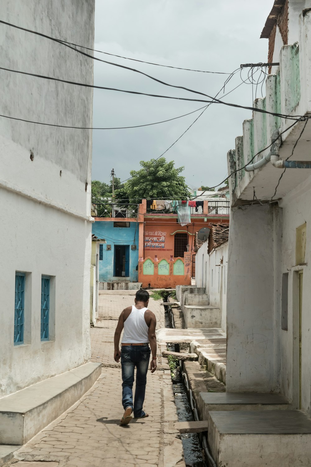 man walking in narrow pathway at daytime