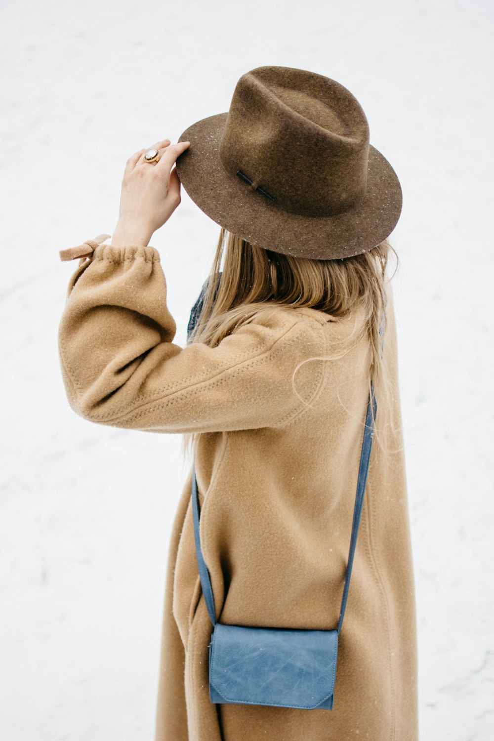 woman holding her hat
