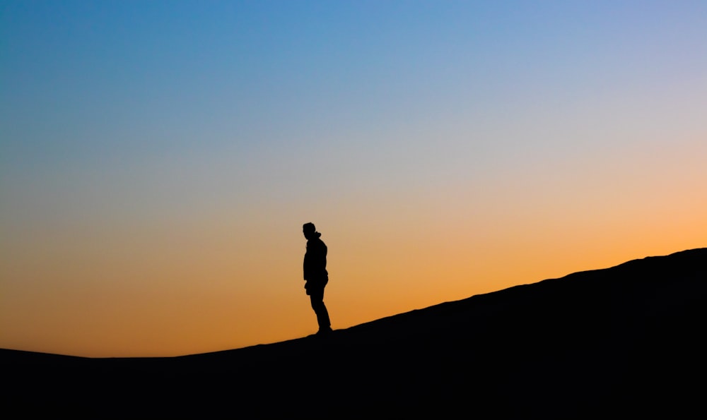 Silhouettenfoto des Mannes während der goldenen Stunde