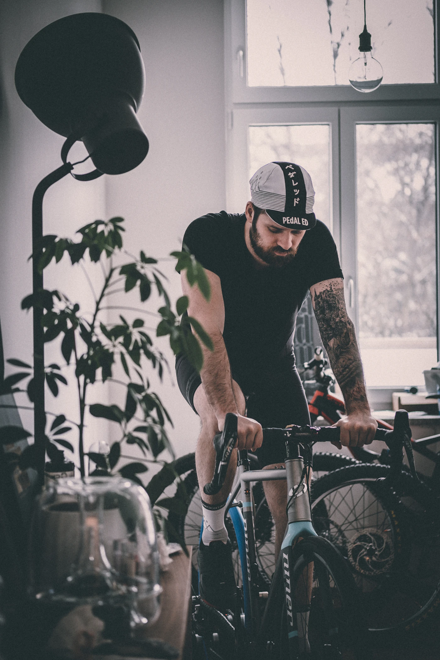 A rider beside a bike among indoor plants