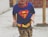 A happy child wearing a soft, sensory-friendly t-shirt with a bright superhero design.