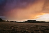 A serene landscape featuring rolling hills under a sunset sky.