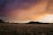 A serene landscape showcasing rolling hills under a vibrant sunset sky.