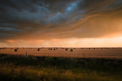 grass field under cloudy sky stormy teams background