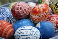 Close-up of colorful wax patterns forming delicate floral motifs on an Easter egg.