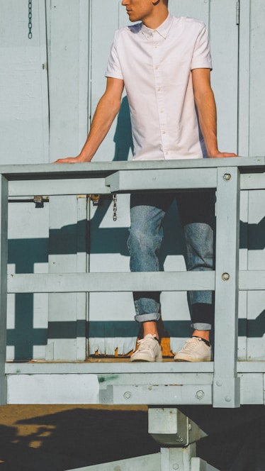 man standing in front of wooden fence