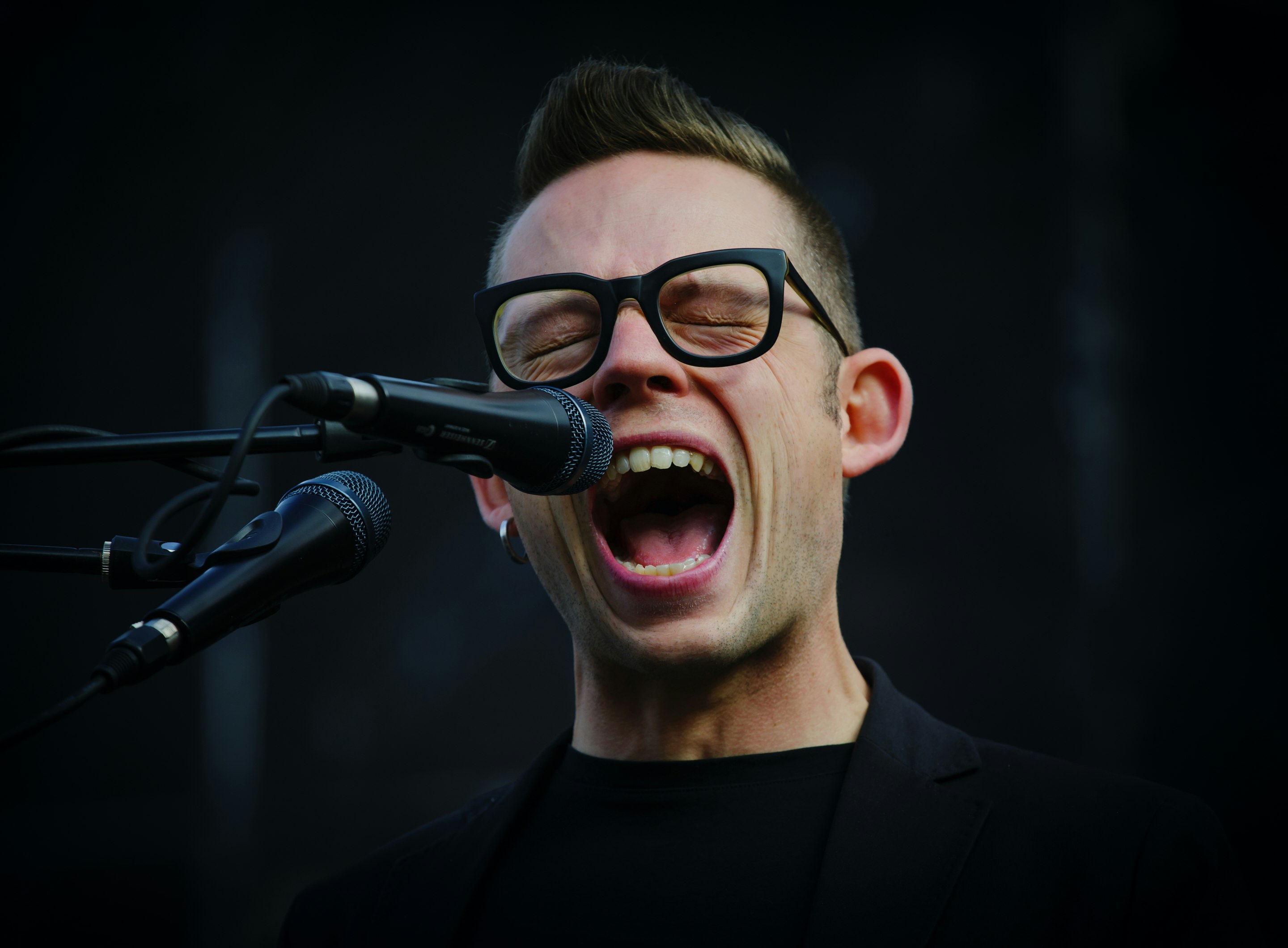 shallow focus photography of man shouting using microphone