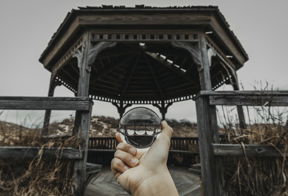 person holding ball in front of gazebo
