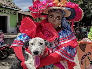Happy dog wearing a custom colorful handmade outfit in a bright Mexican street.