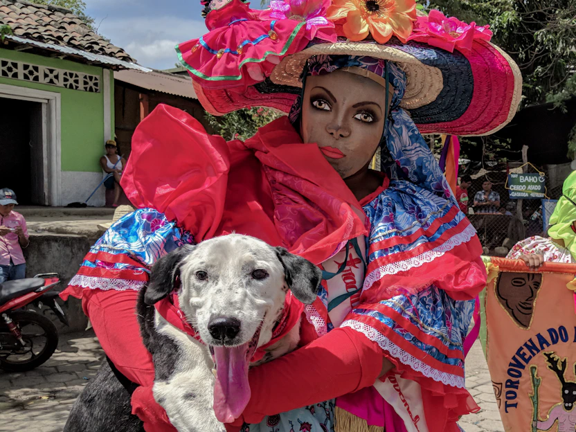 A cheerful dog and cat wearing colorful handmade outfits from Colitas Viva in a bright, vibrant setting.