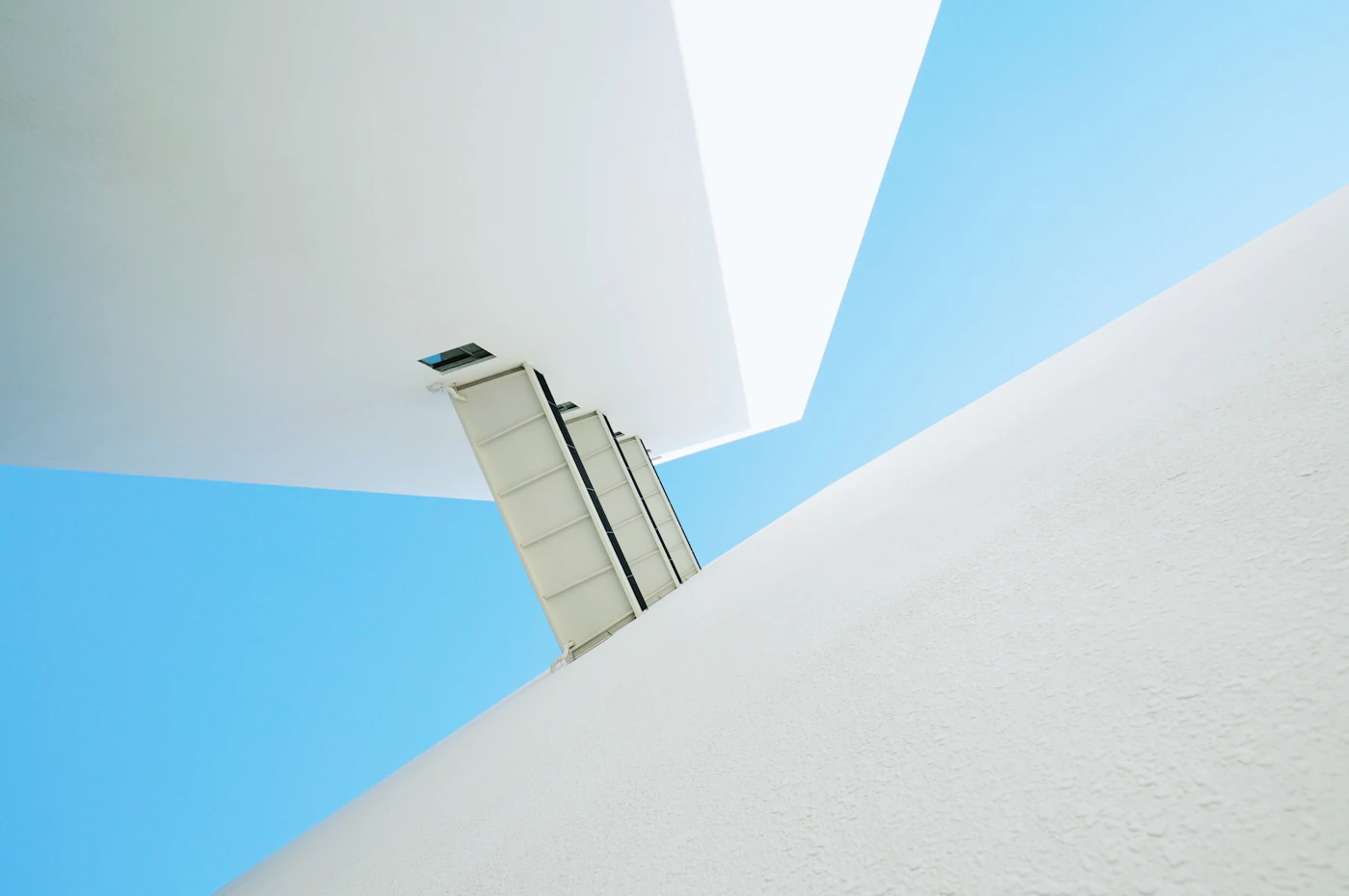 Upward view of a clean white high-rise structure