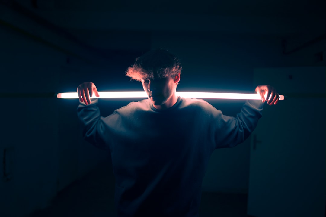 low light photography of man in gray sweatshirt