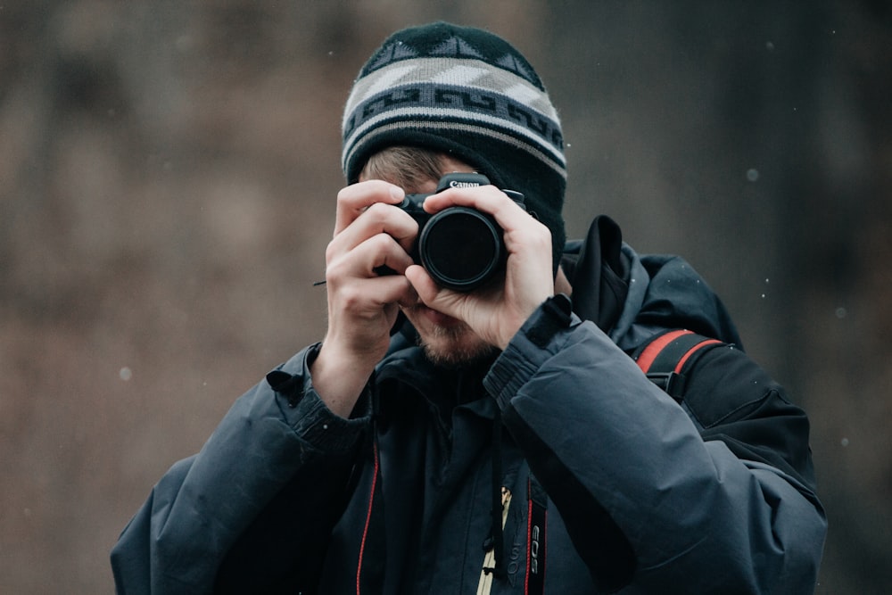 person holding Canon DSLR camera