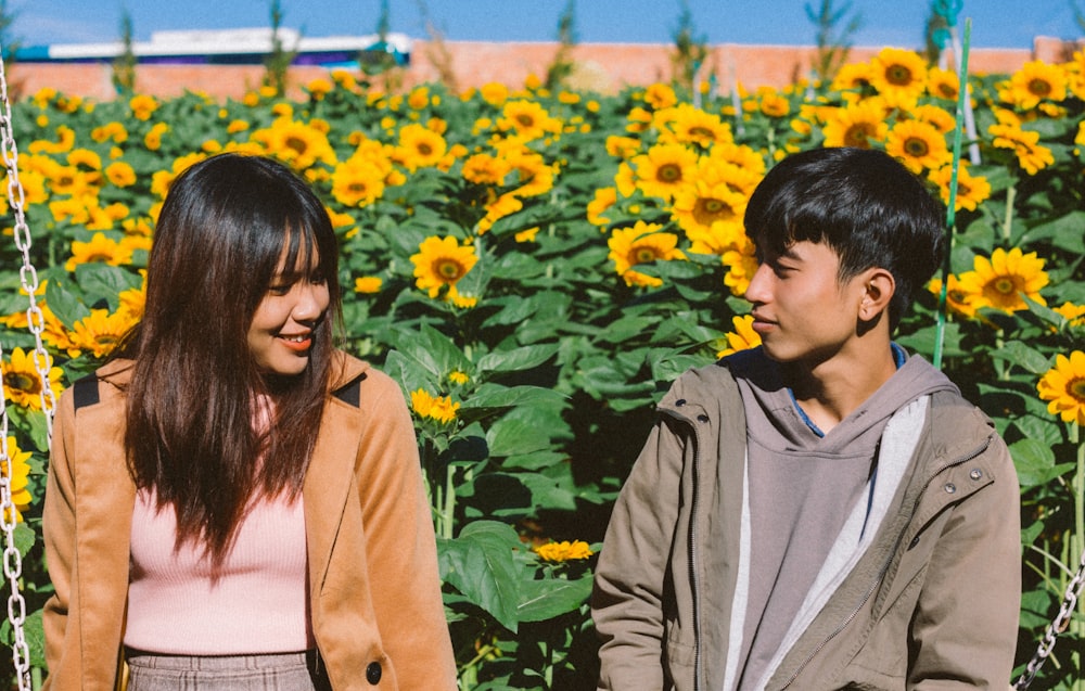 Paar sitzt neben Sonnenblumenfeld