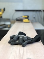A colorful array of gloves laid out on a wooden table, showcasing different styles and sizes.