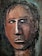 A textured, abstract portrait of a human face with a serious expression. The features are roughly painted and textured, giving a rugged, almost carved appearance. The eyes are deep blue, contrasting against the earthy brown tones of the face. Dark hair is depicted with rough, black strokes.