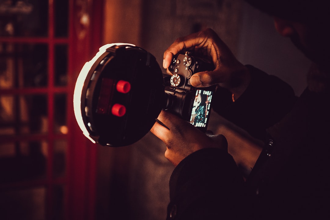 person holding DSLR camera inside room