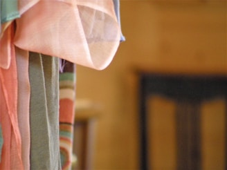 Close-up of colorful patterned fabrics draped over a vintage wooden chair